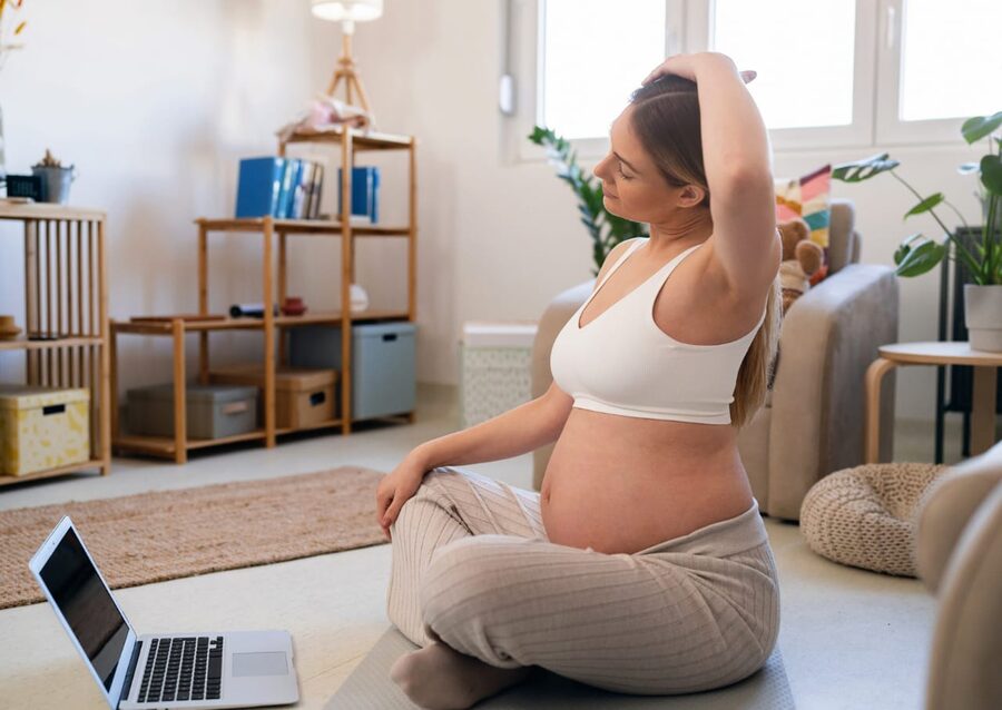 Gestante fazendo exercício em casa com segurança